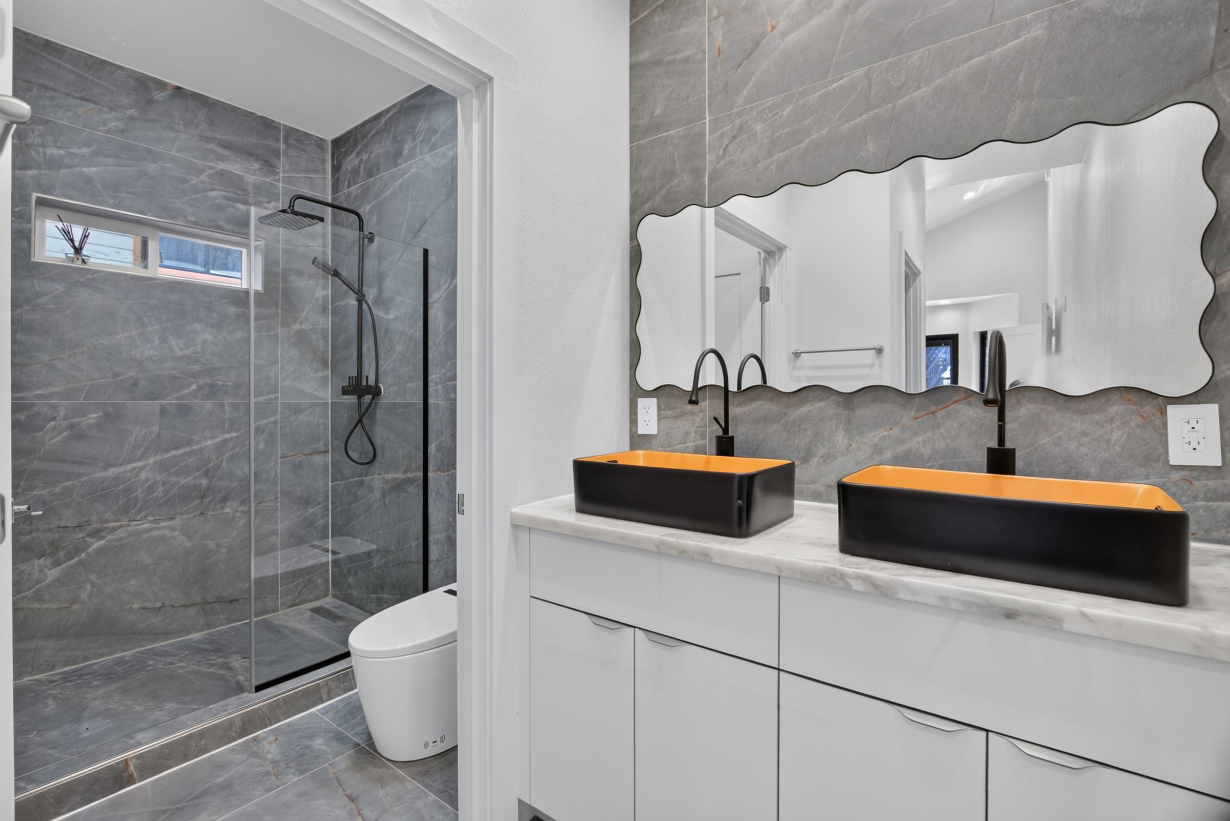 Bathroom with a glass shower and twin vessel sinks