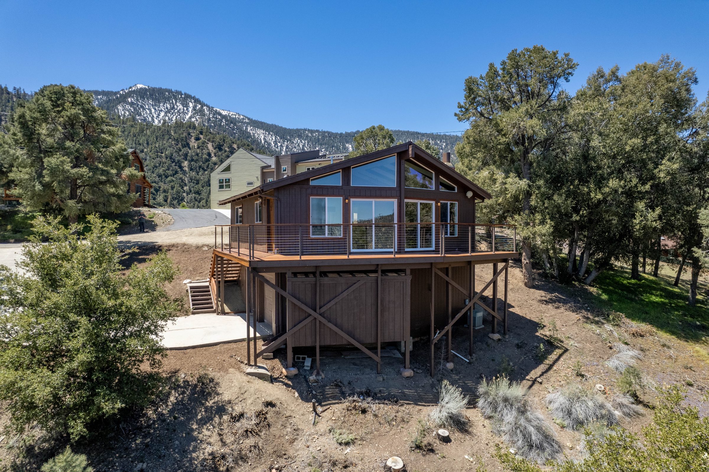 Modern mountain cabin with a snow-capped peak behind it