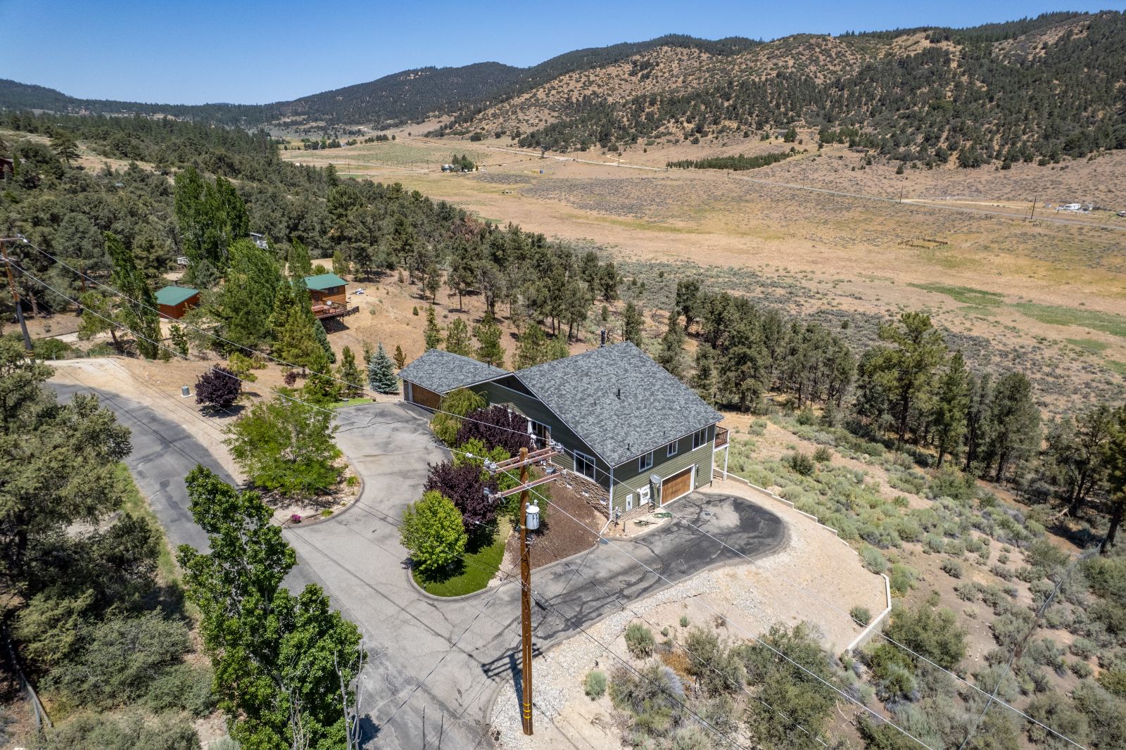 Aerial view of the home, drive and the valley beyond